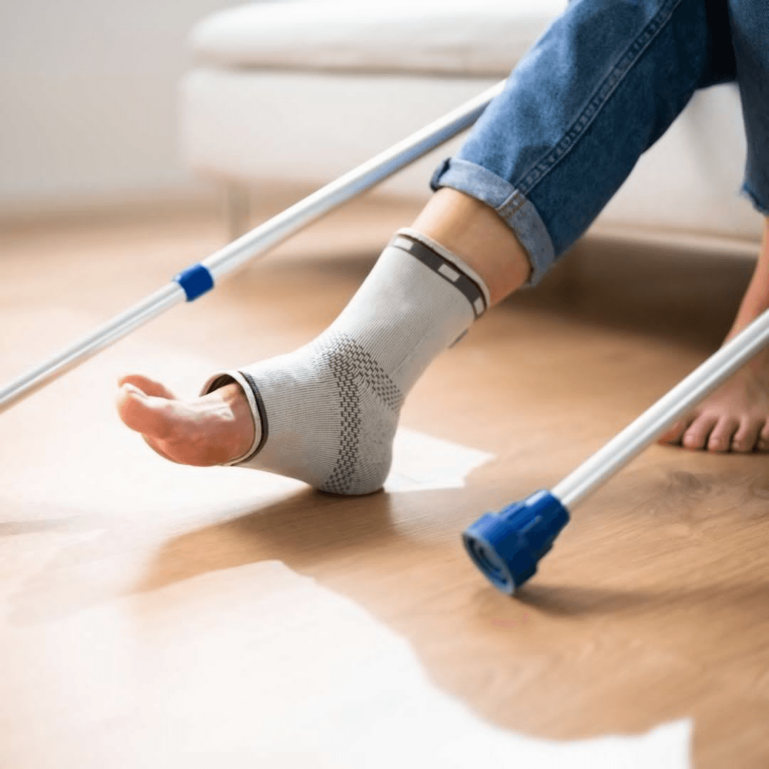 Knit ankle compression sleeve worn with crutches nearby